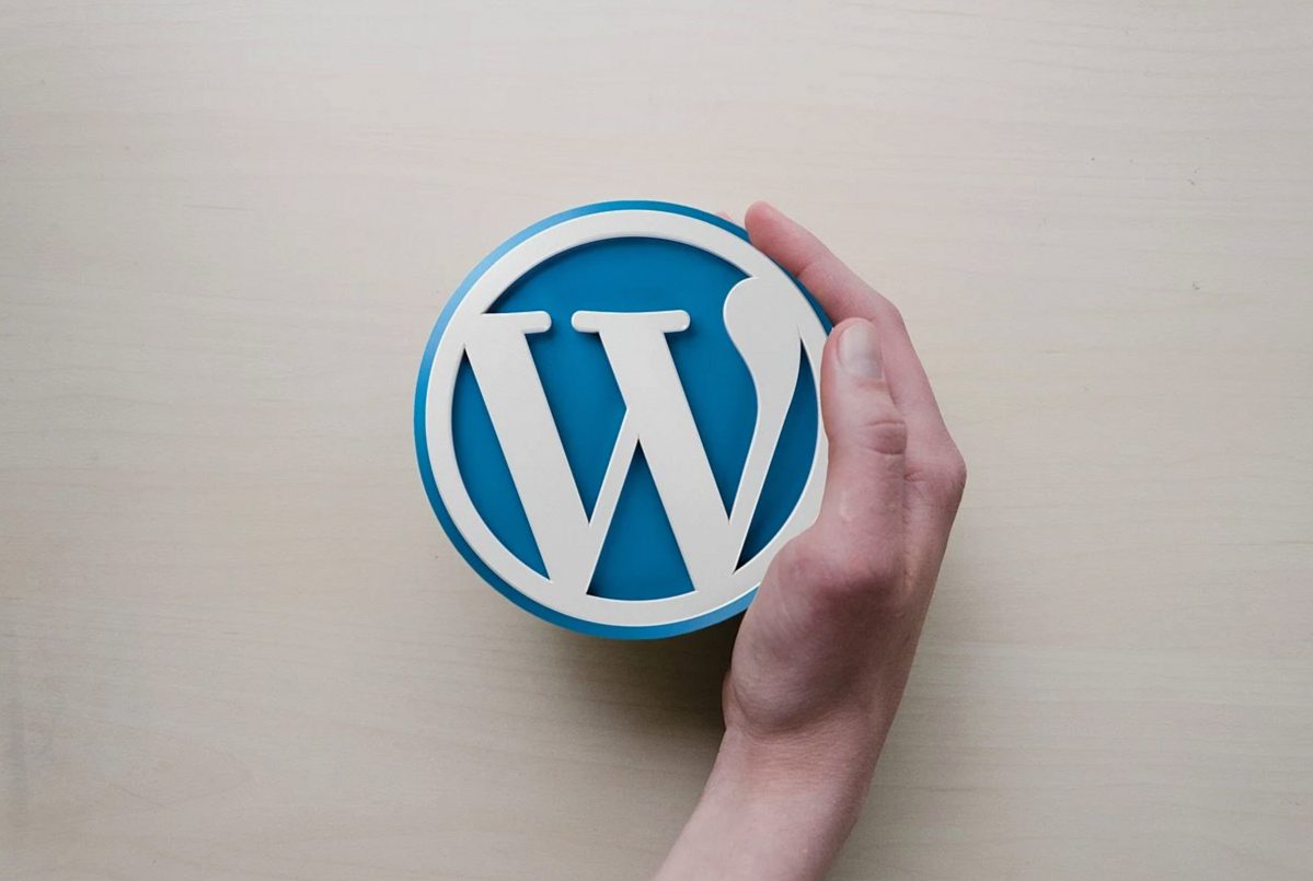 WordPressのロゴを持つ手、ブログのシンボルとアイコンデザイン